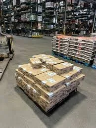 Pallet of boxed goods in a warehouse, with shelves of products in the background.
