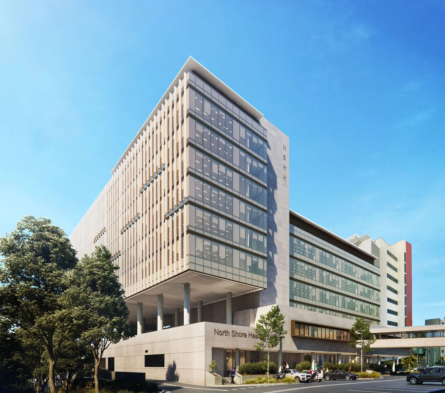 Modern multi-story hospital building with glass windows and a sign that reads "North Shore." Trees and cars in front under a blue sky.