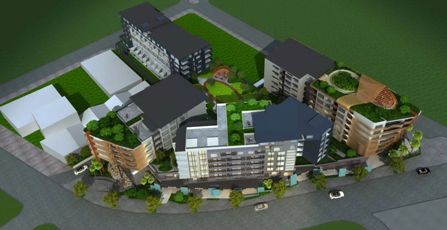 A 3D-rendered digital model of a modern residential complex with multiple buildings, green roofs, central gardens, and surrounding roads with parked cars.