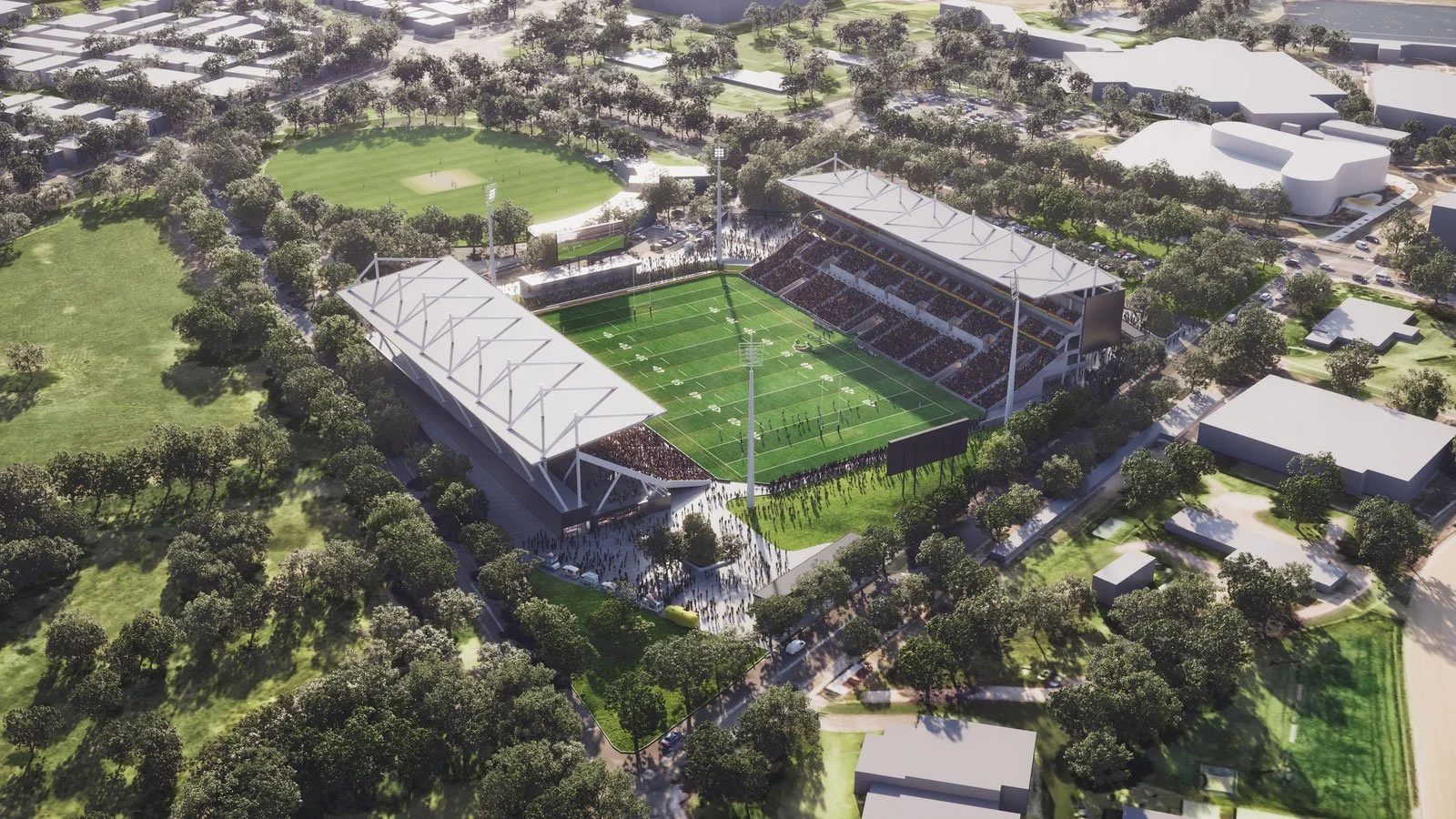 Aerial view of a modern football stadium with spectators, surrounded by trees and green fields