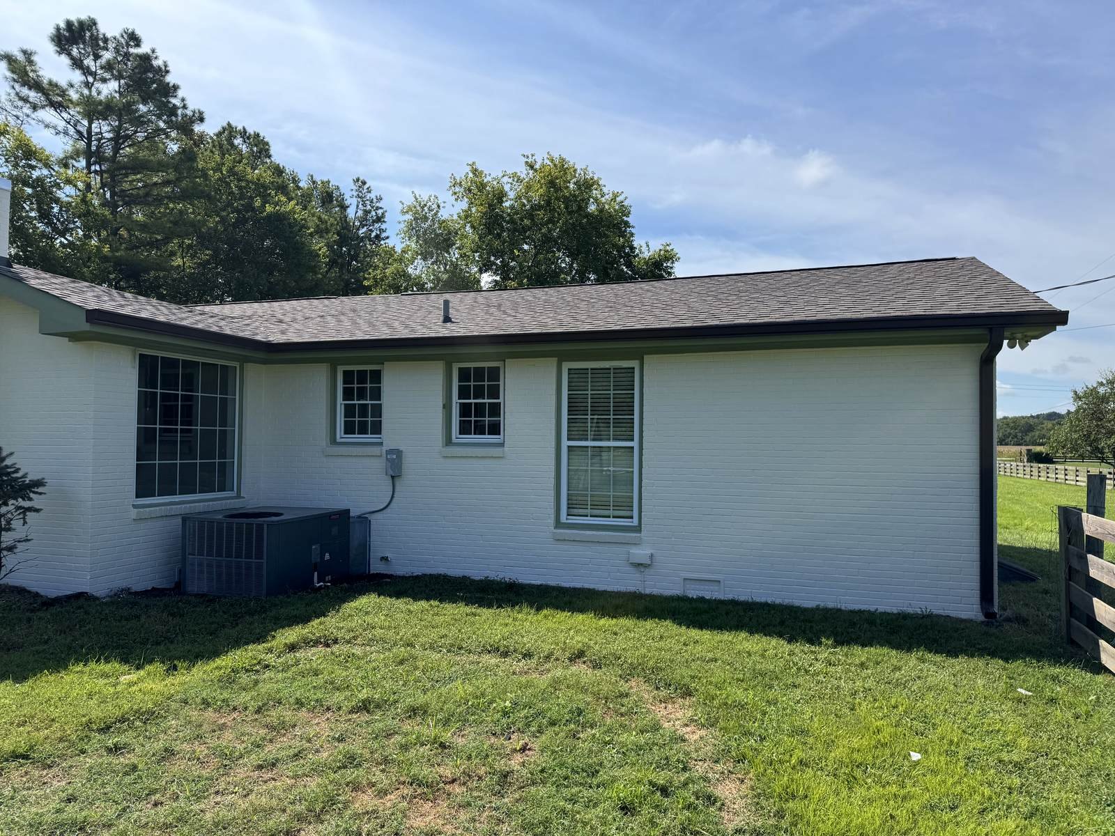 After: the same home with new seamless gutters and fresh white paint, Franklin area