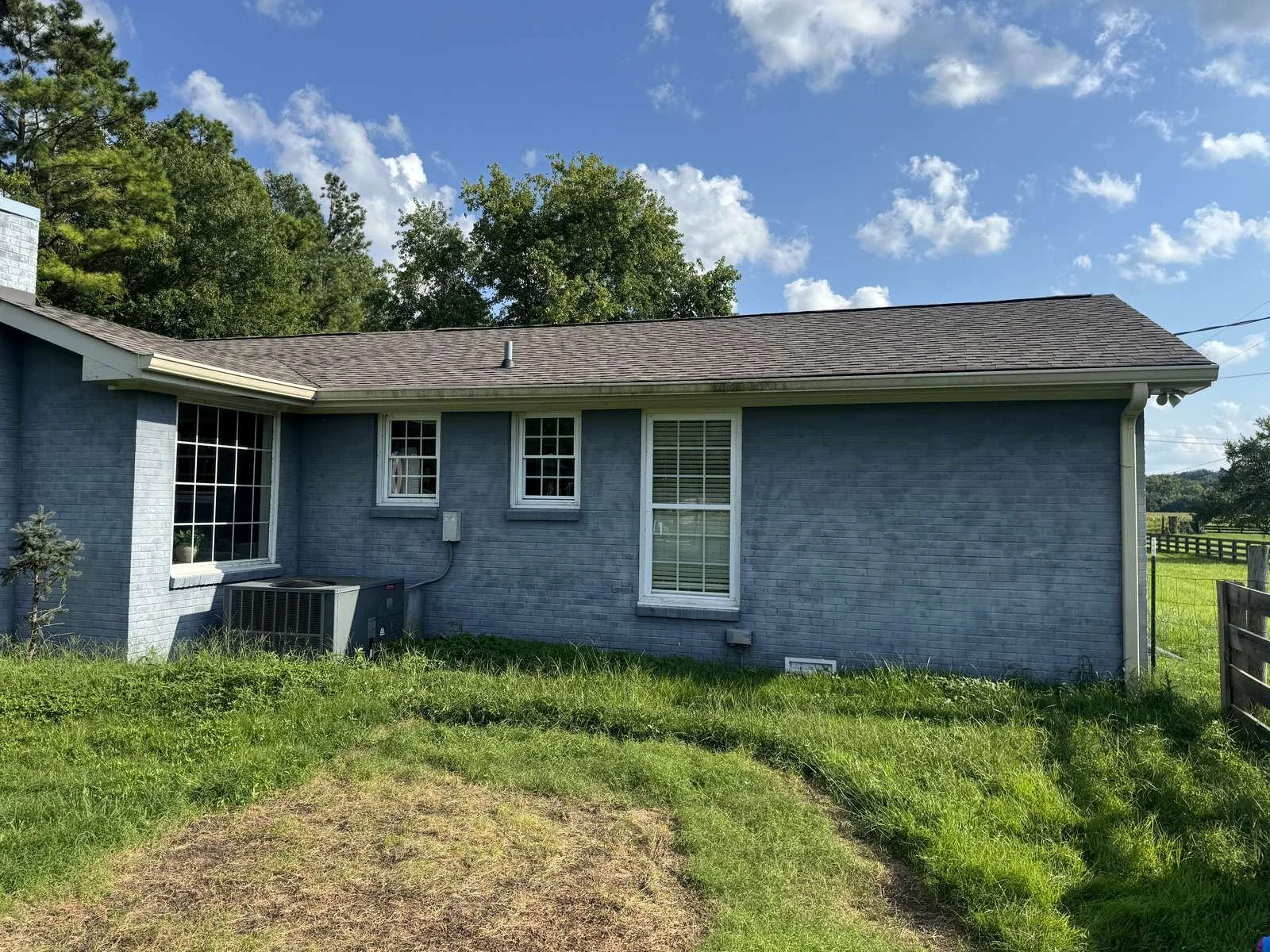 Before: rear of a Franklin-area brick ranch with old almond-colored gutters and downspout