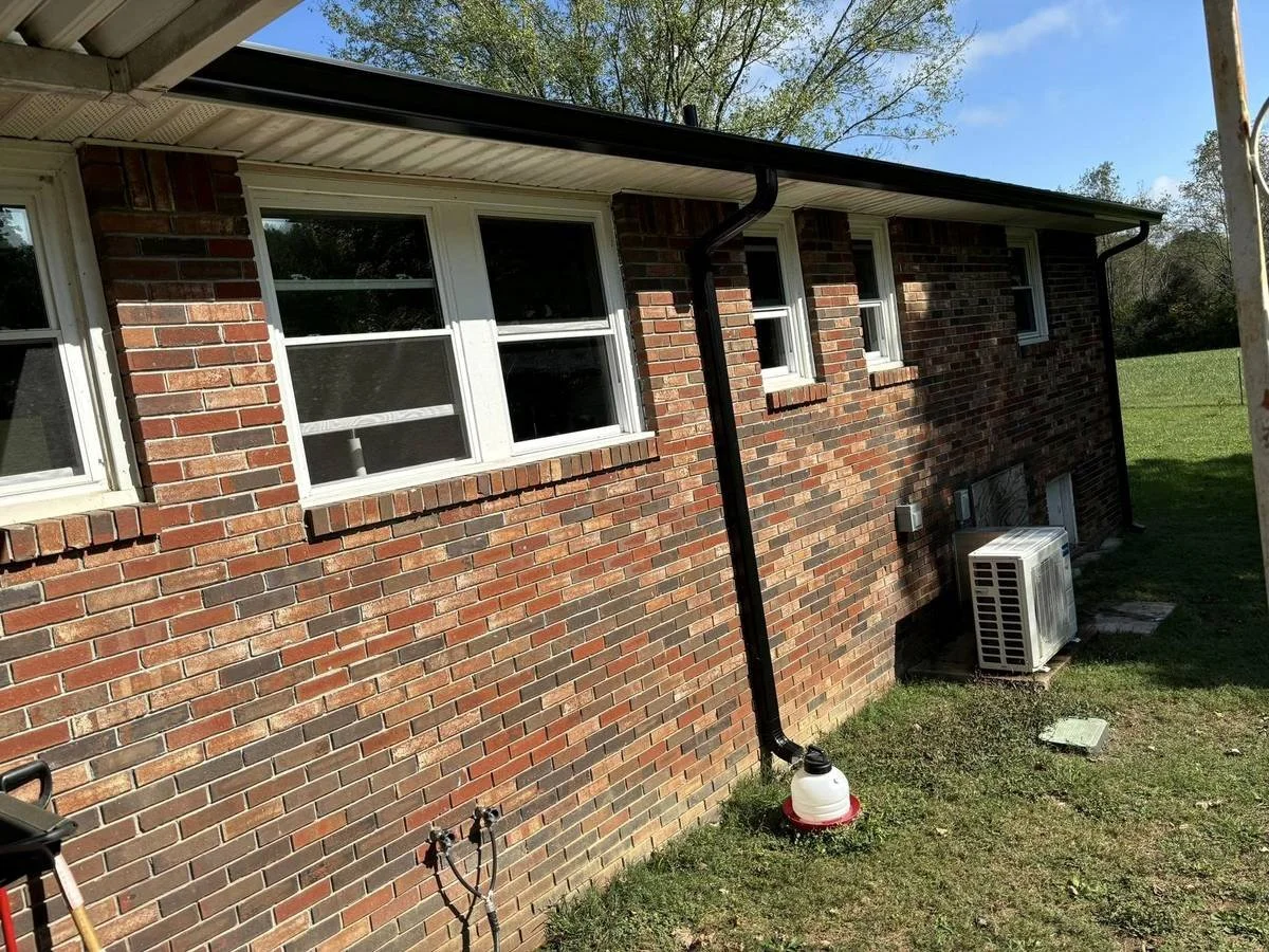 Red brick home with new gutters and downspouts