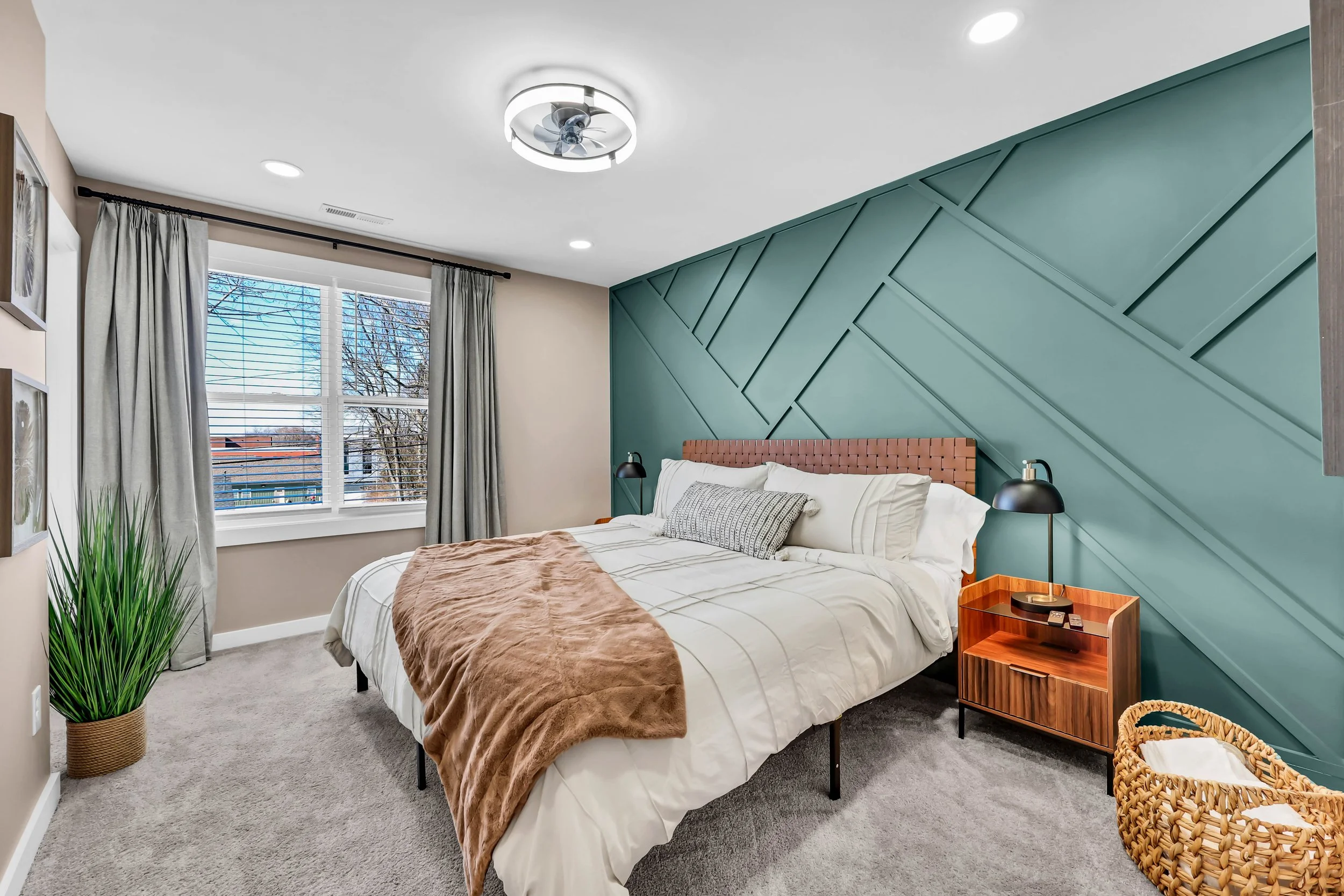 A modern bedroom with a bed, nightstand, and decorative feature wall