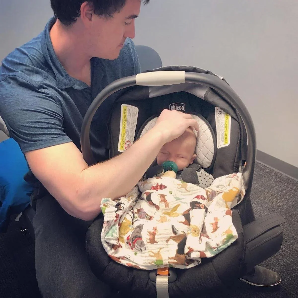 Baby in car seat showing head tilt during torticollis symptoms evaluation in Liberty MO