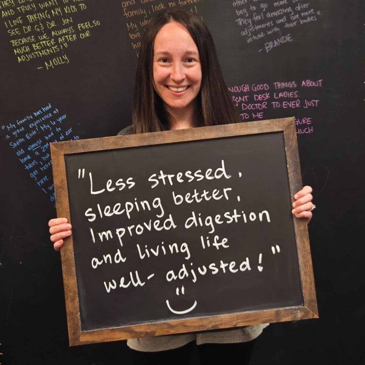 Woman holding chalkboard about less stress better sleep and improved digestion after care in Liberty MO