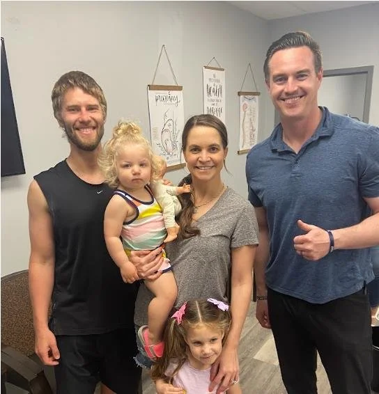 Father holding children during family chiropractic visit