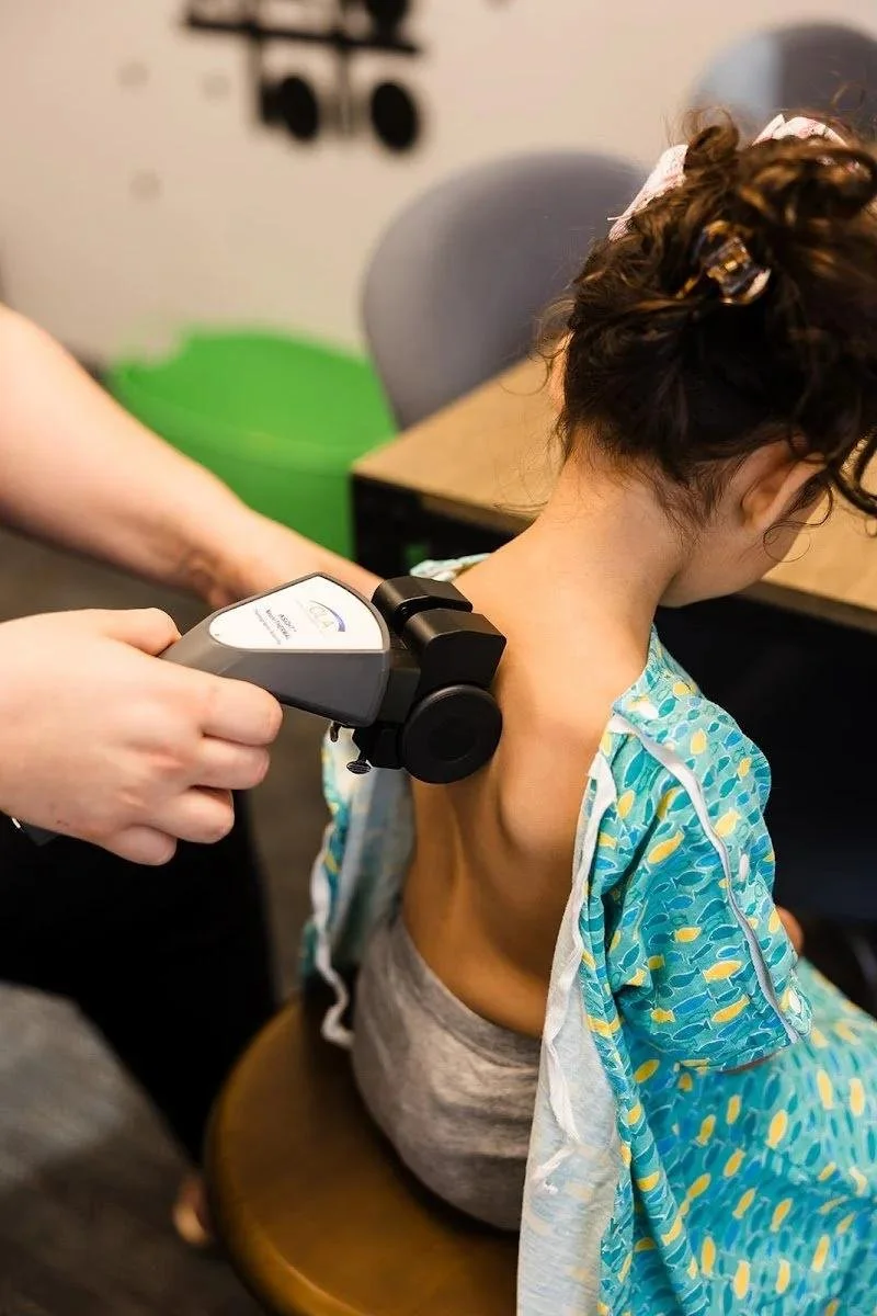 Girl receiving gentle chiropractic adjustment for sensory processing treatment in Liberty MO