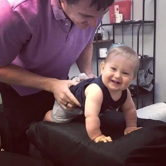 Baby being held gently during reflux chiropractic treatment
