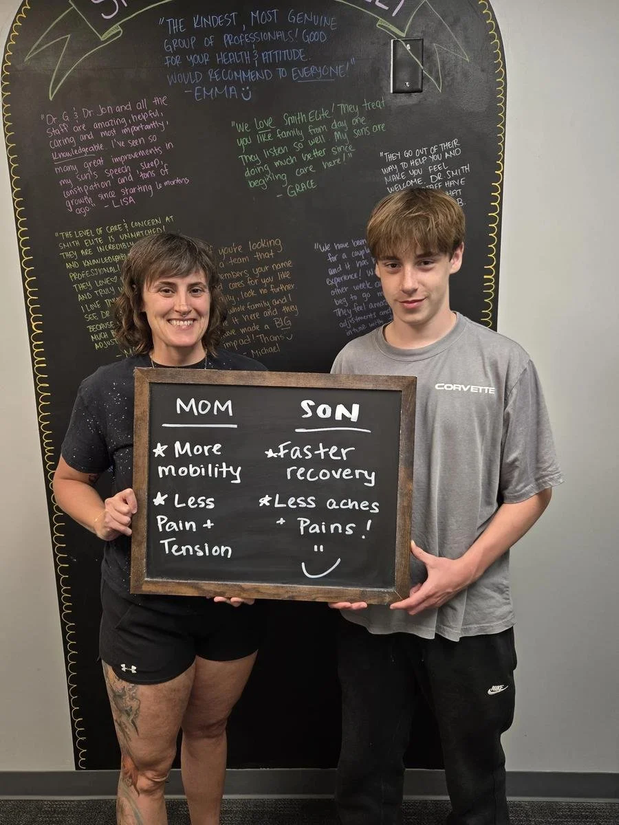Mom and son holding chalkboard about more mobility and faster recovery for athletic performance in Liberty MO