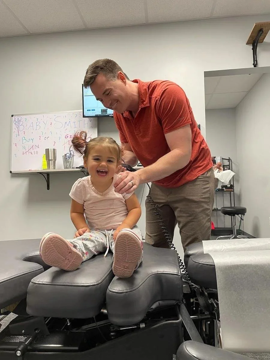 Chiropractor adjusting child in treatment room during autism chiropractic care in Liberty MO