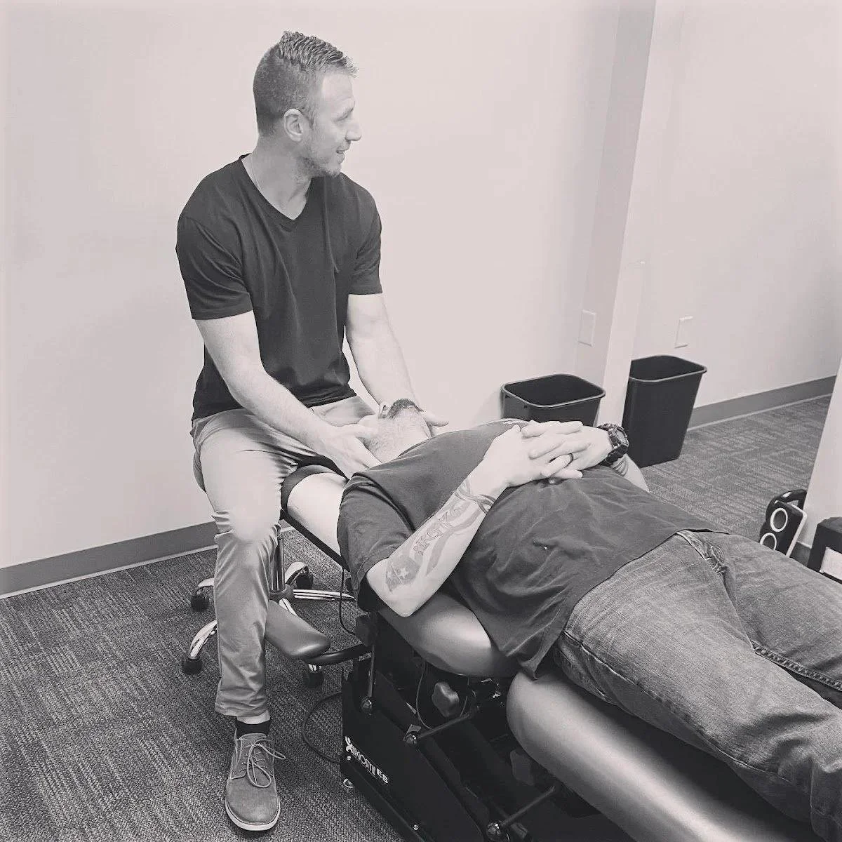 Patient lying on table receiving spinal adjustment for neck pain symptoms