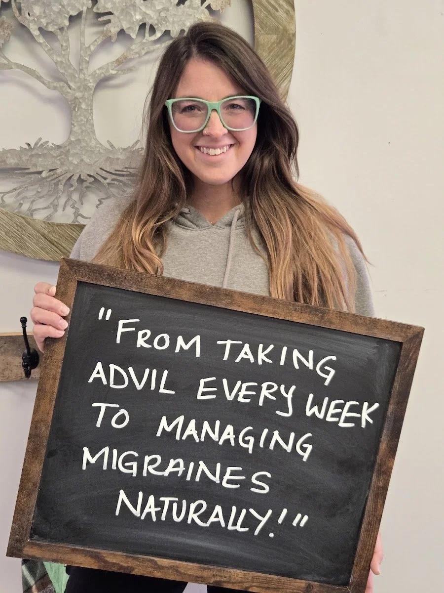 Woman holding chalkboard about managing migraines naturally