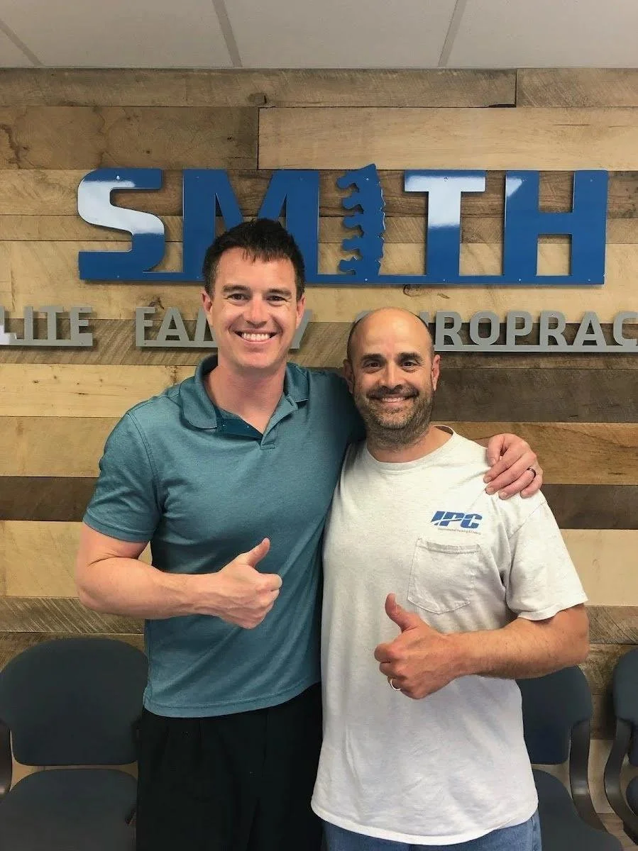 Dr and guy patient giving thumbs up after back pain recovery