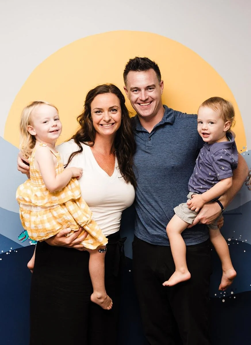 Young family with baby representing postpartum chiropractic care
