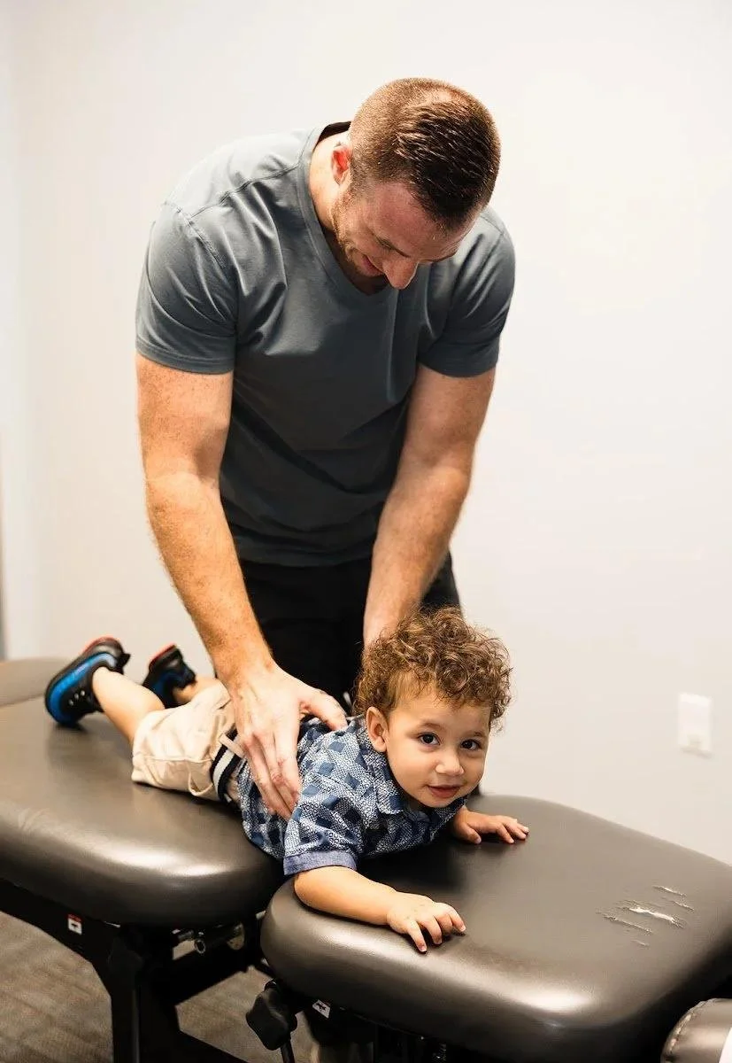 Dr Garrett Smith gently adjusting boy during autism nervous system chiropractic care in Liberty MO