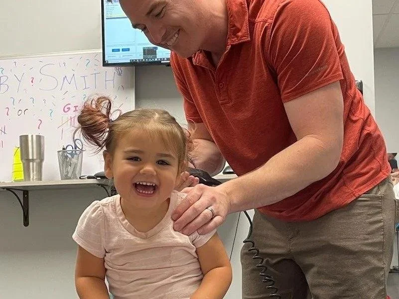 Dr Garrett Smith gently adjusting toddler during childhood anxiety chiropractic treatment in Liberty MO