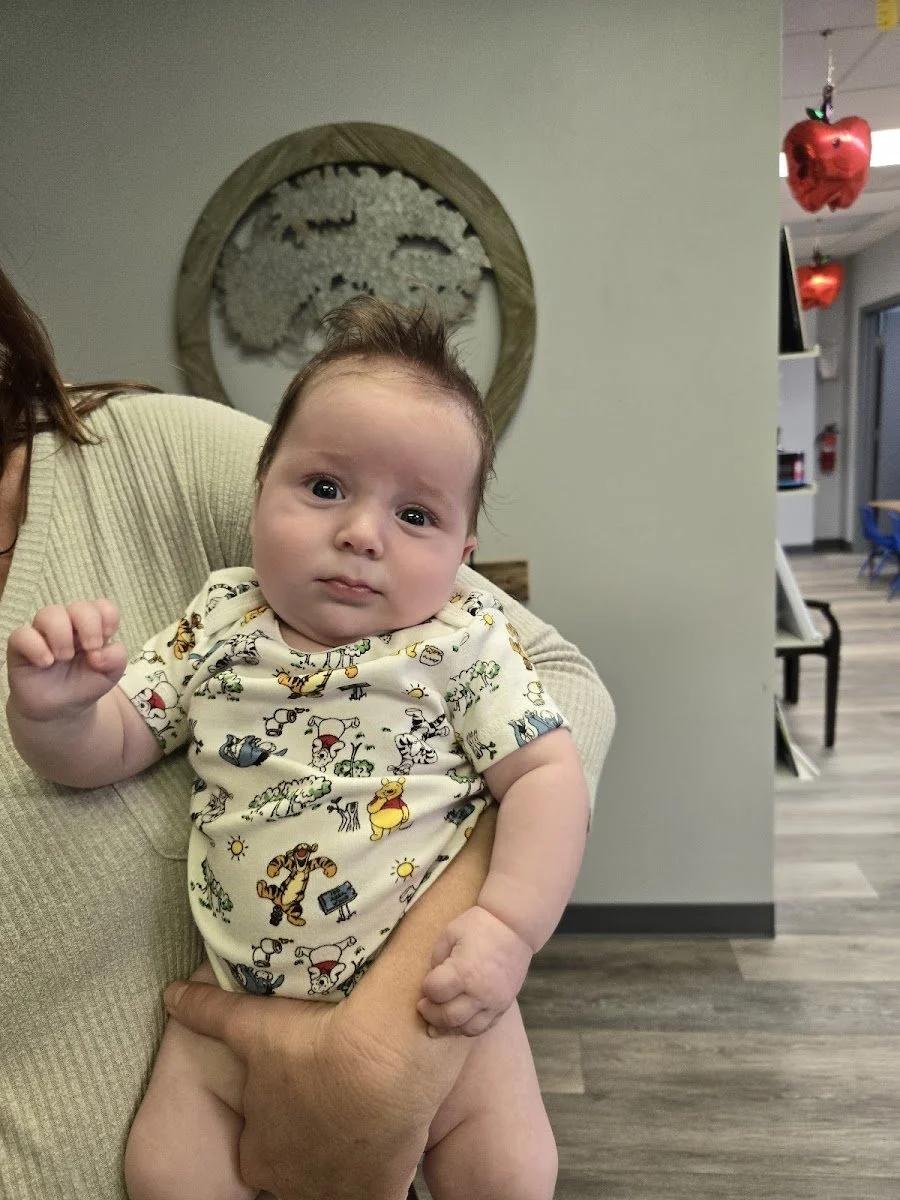 Healthy baby relaxing after chiropractic care for chronic ear infections in Liberty MO