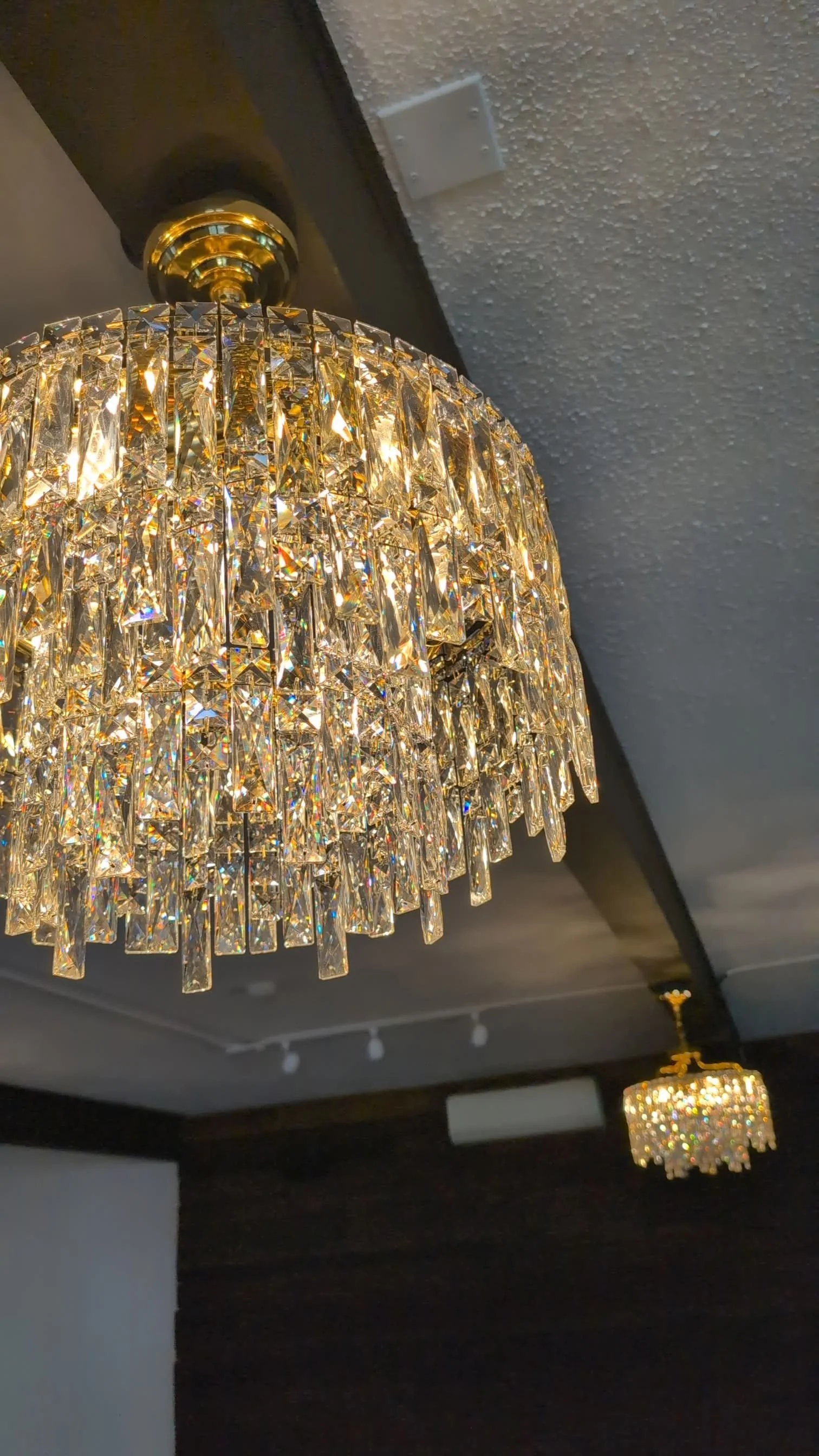 Crystal chandelier hanging from the ceiling in a dimly lit room.