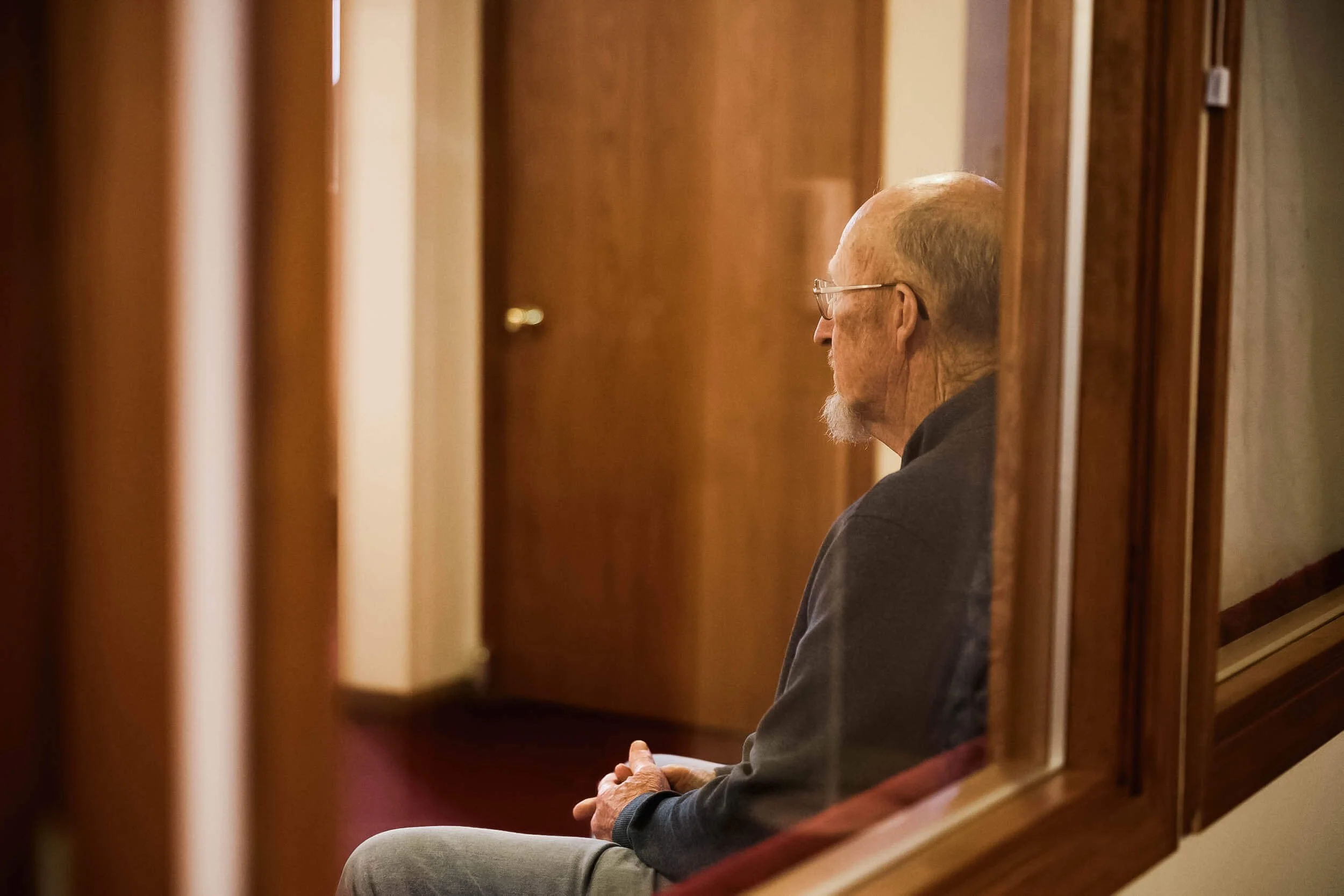 An older gentleman sits quietly by himself in Crown Hill Church's sanctuary before the church service begins.