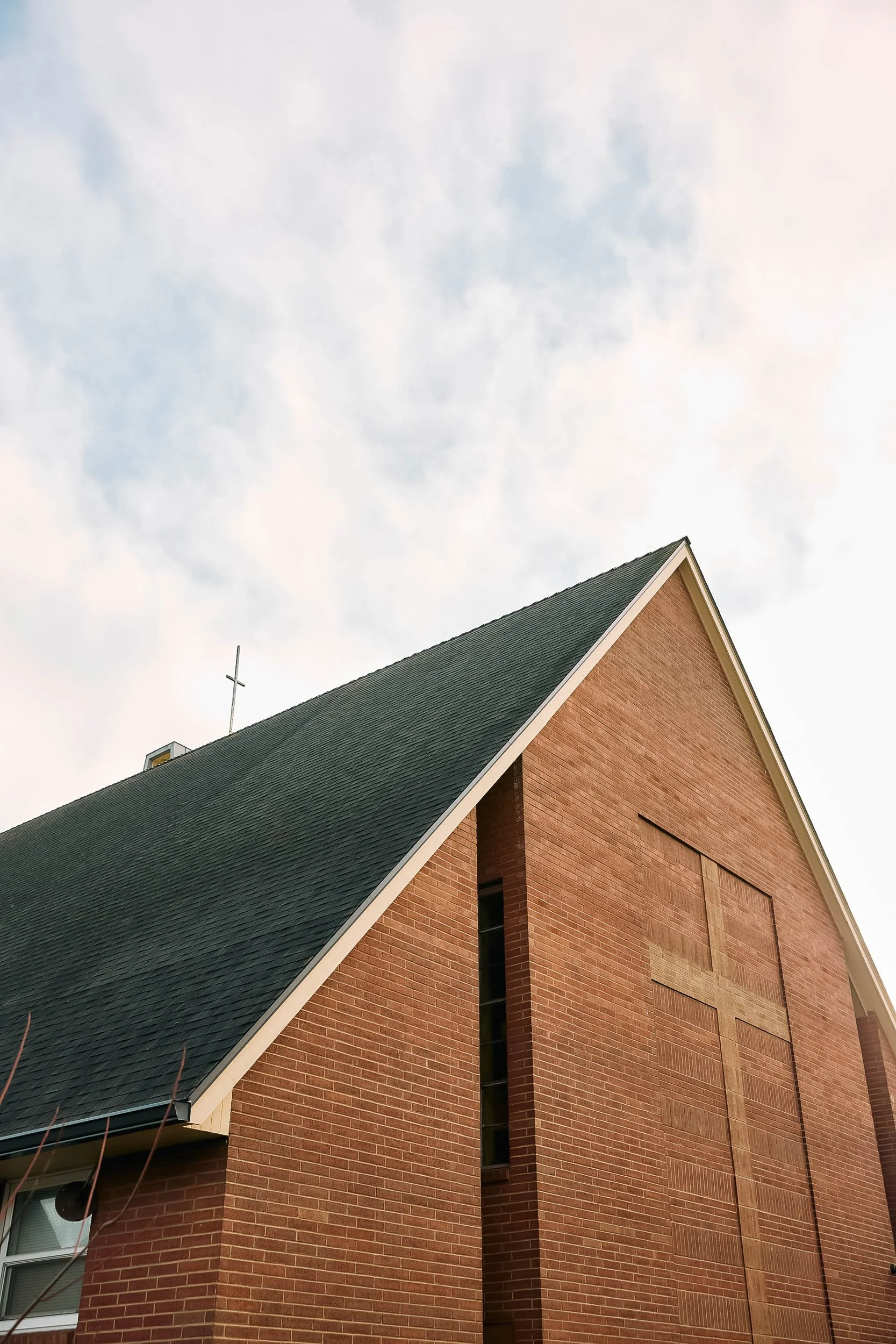 The exterior of Crown Hill Church showing the cross on the steeple and a brick cross on the front of the building in Seattle's Crown Hill neighborhood.