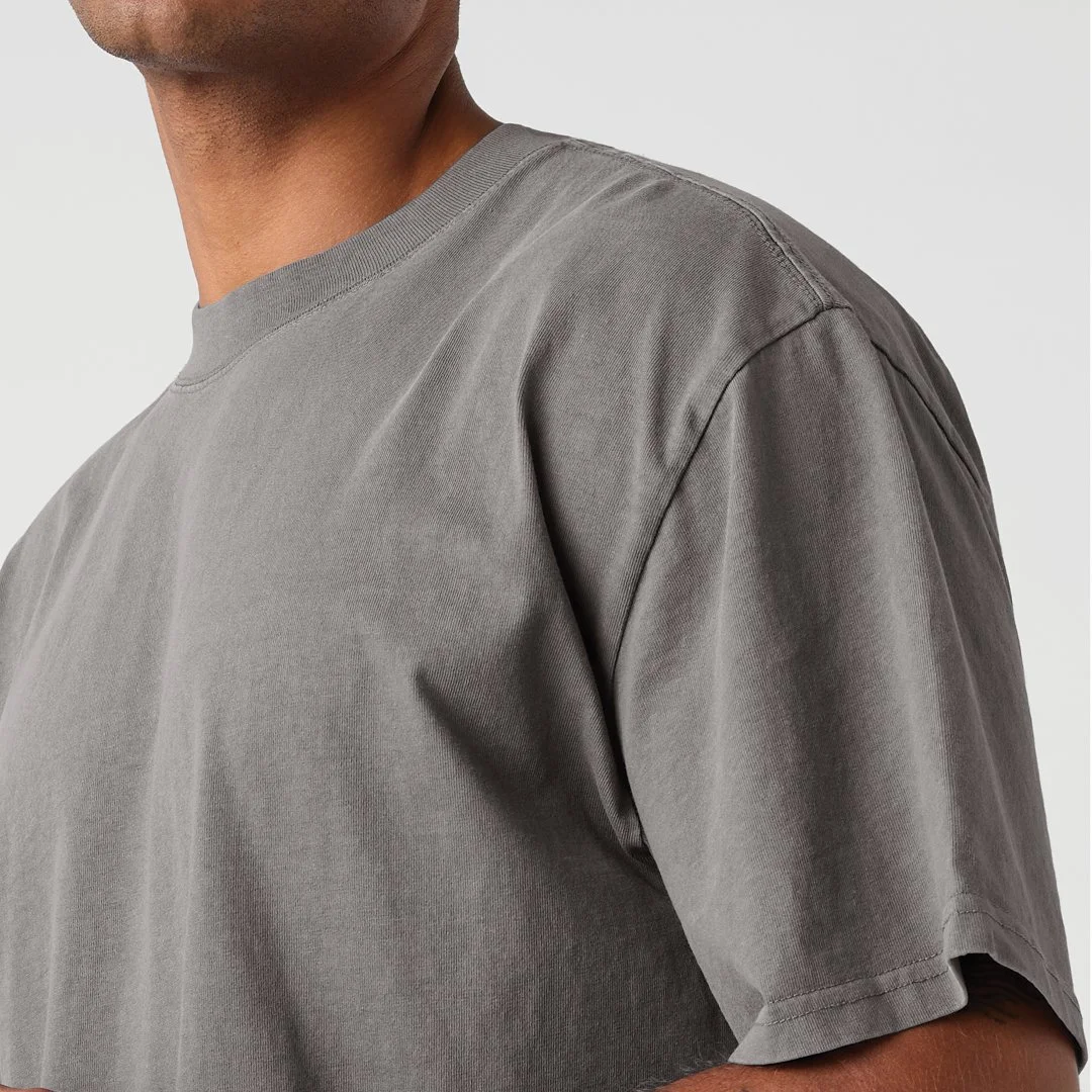 Close-up of a person wearing a plain gray T-shirt, focusing on the shoulder and chest area.