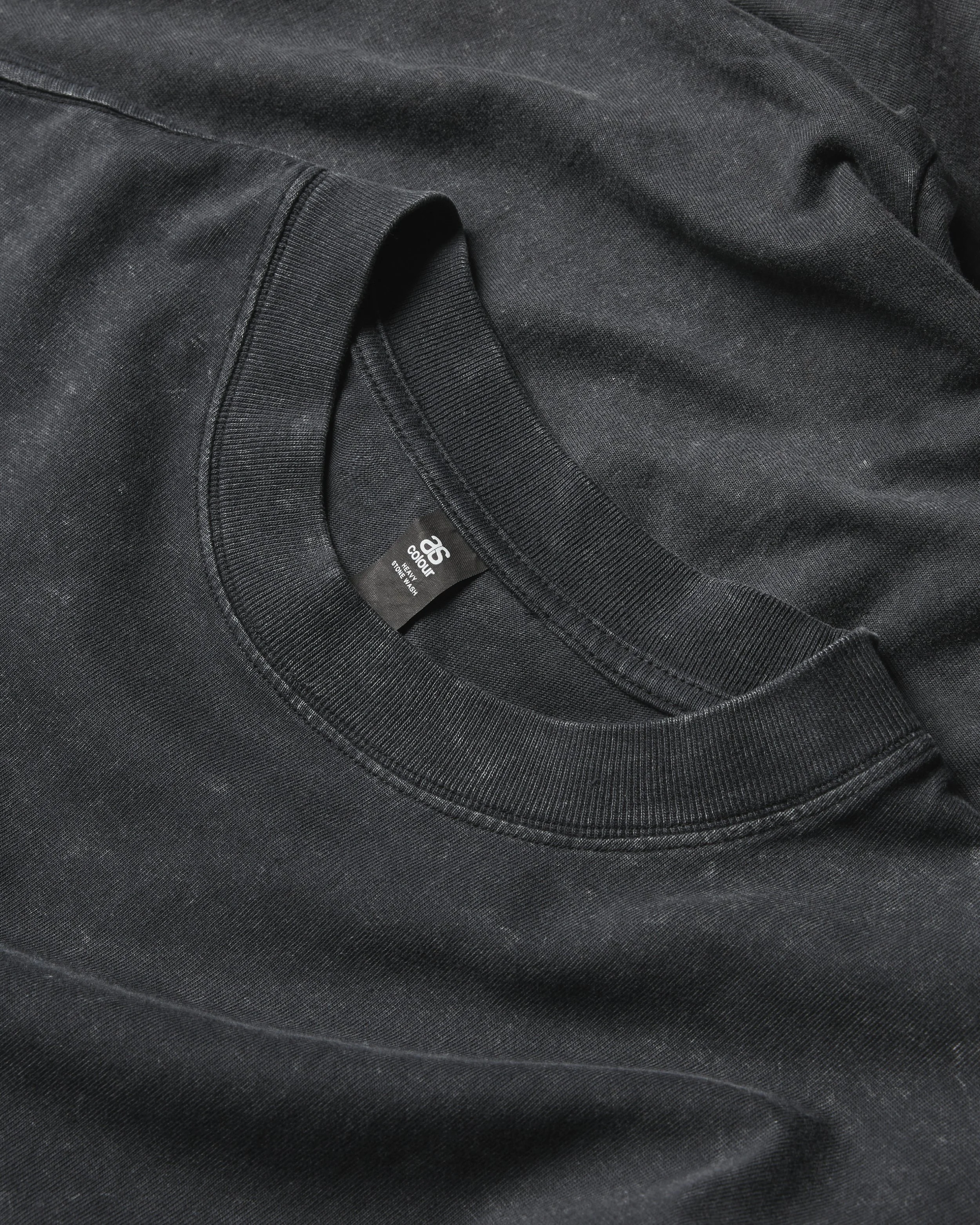 Close-up photo of black athletic clothing, showing the fabric and stitching detail with a visible clothing tag.