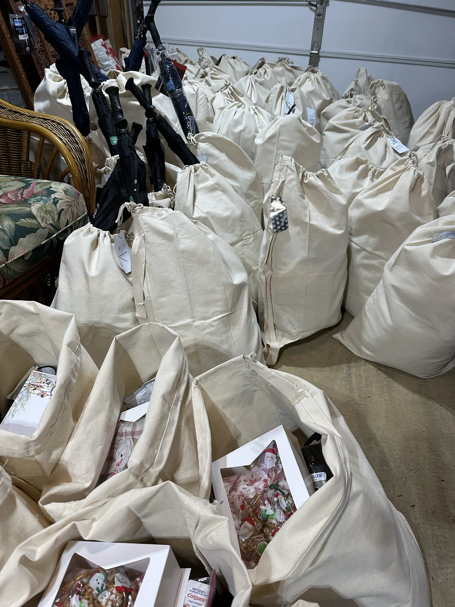 Large collection of donation bags filled with gifts and supplies prepared for holiday distribution.