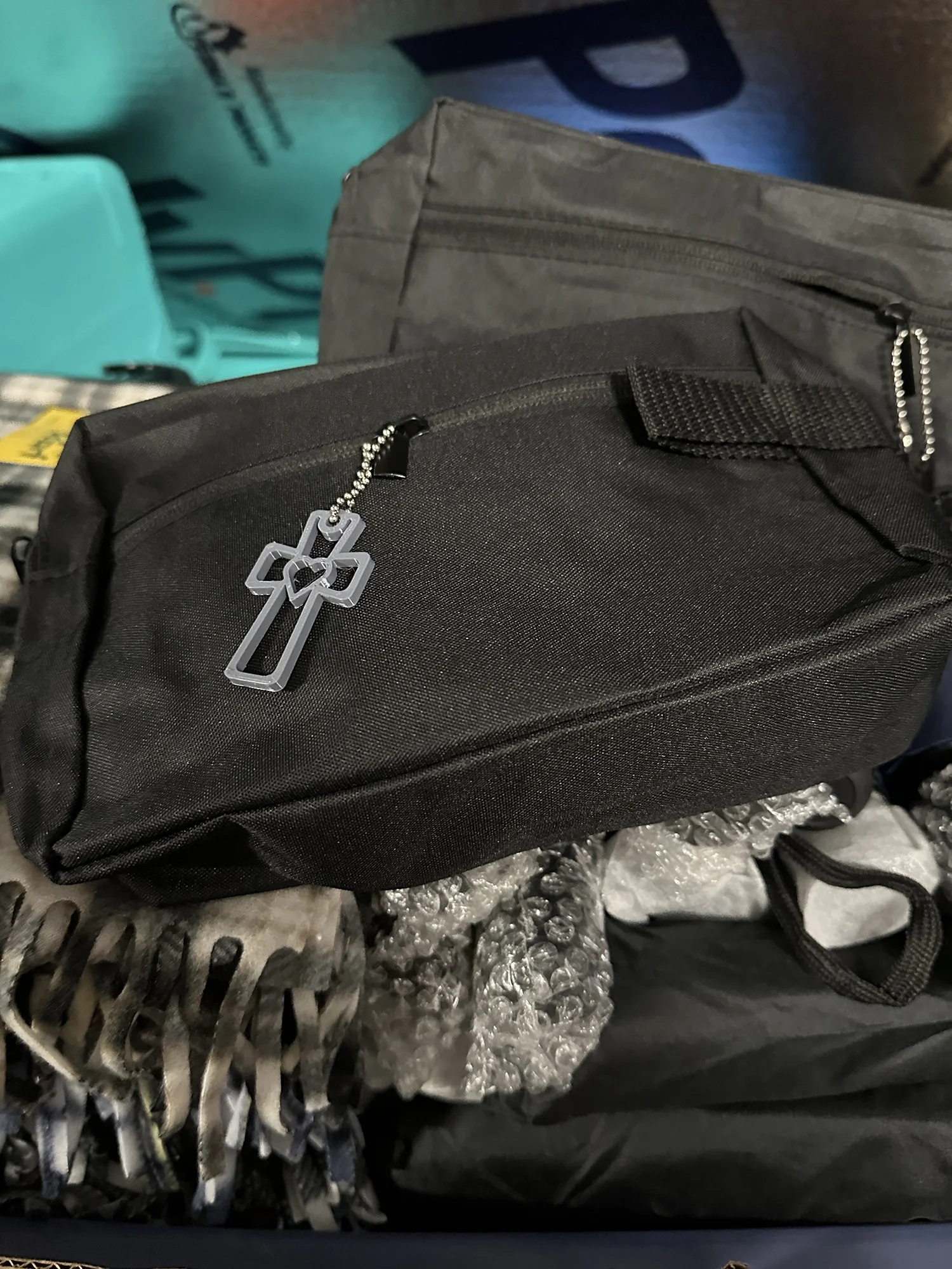 Black toiletry bags with cross zipper pulls filled with donated care items for distribution.