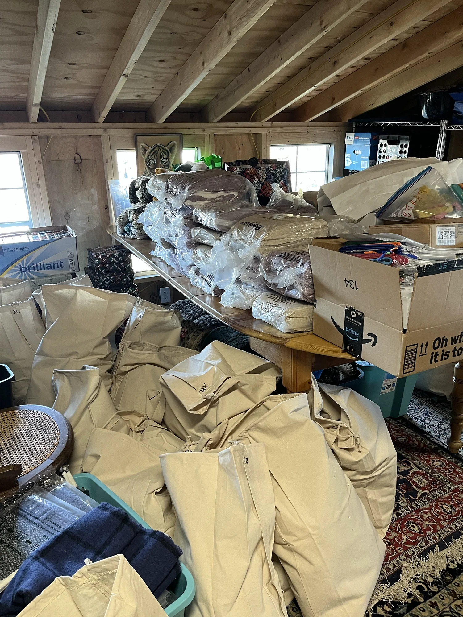 Stacks of donated blankets, supplies, and filled care bags organized in a storage space for distribution.