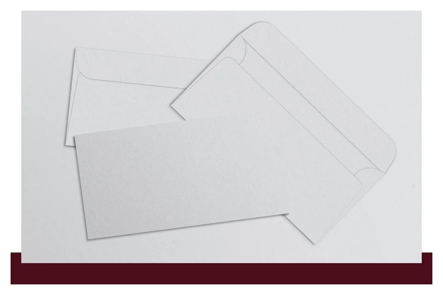 Two overlapping sheets of light gray paper with faint pencil-like lines, one partly folded and angled over the other on a plain background.
