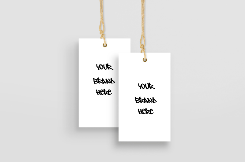 Two white price tags with "YOUR BRAND HERE" hang from golden strings against a light gray background.