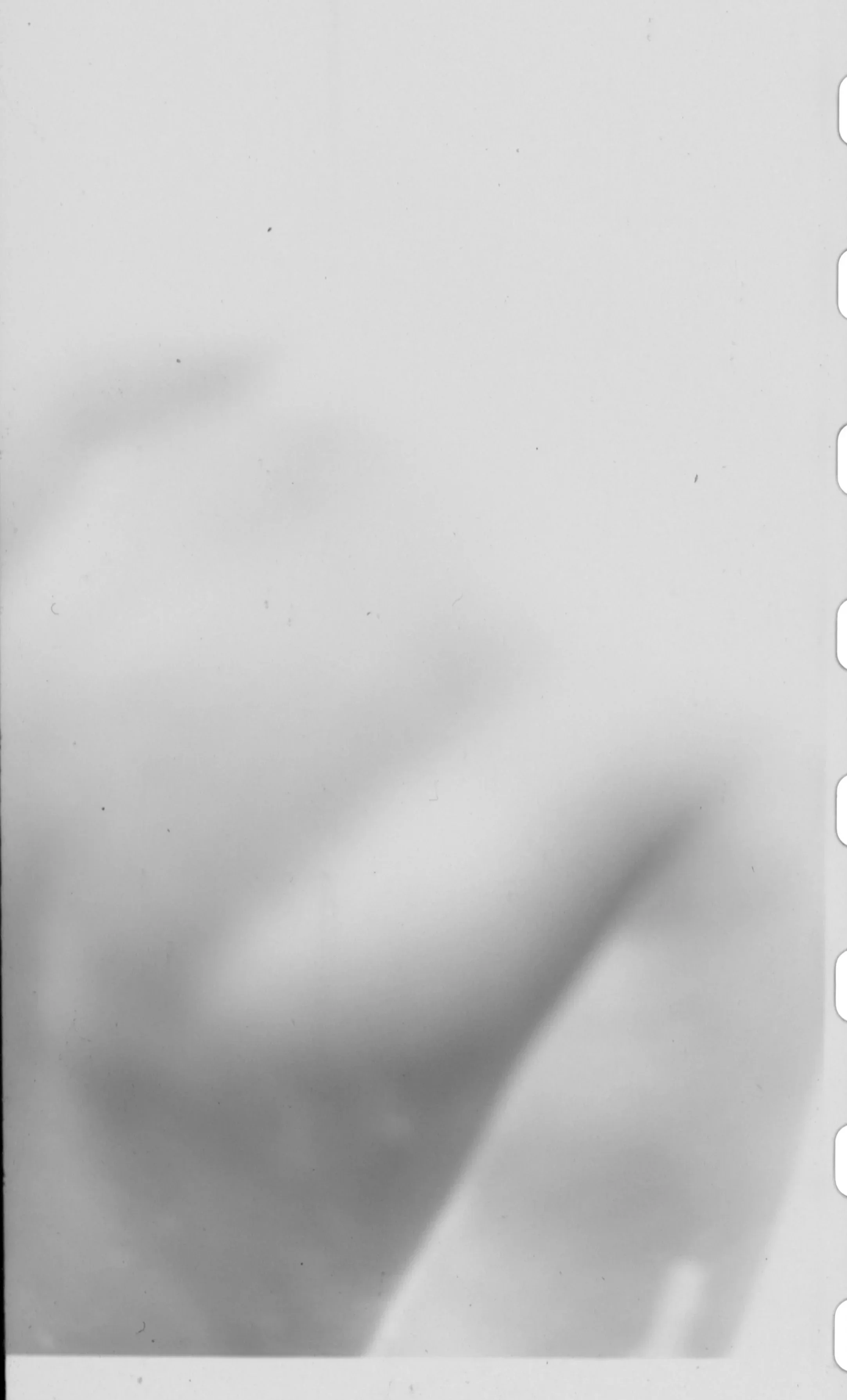 Blank white sheet of paper with slight shadows and some small black specks.