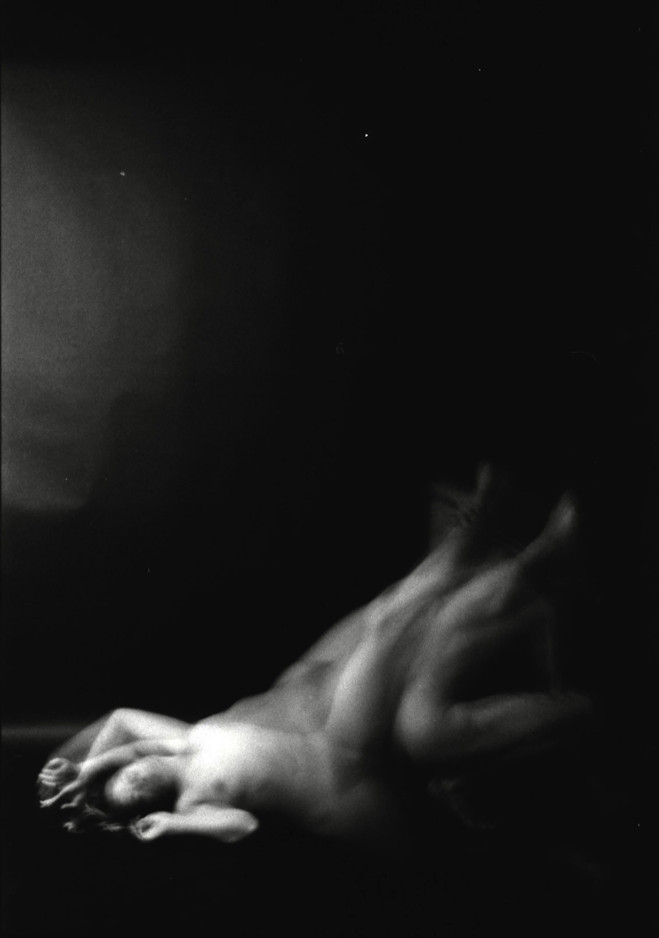 Close-up black and white photo of a hand holding an object, with a dark background.