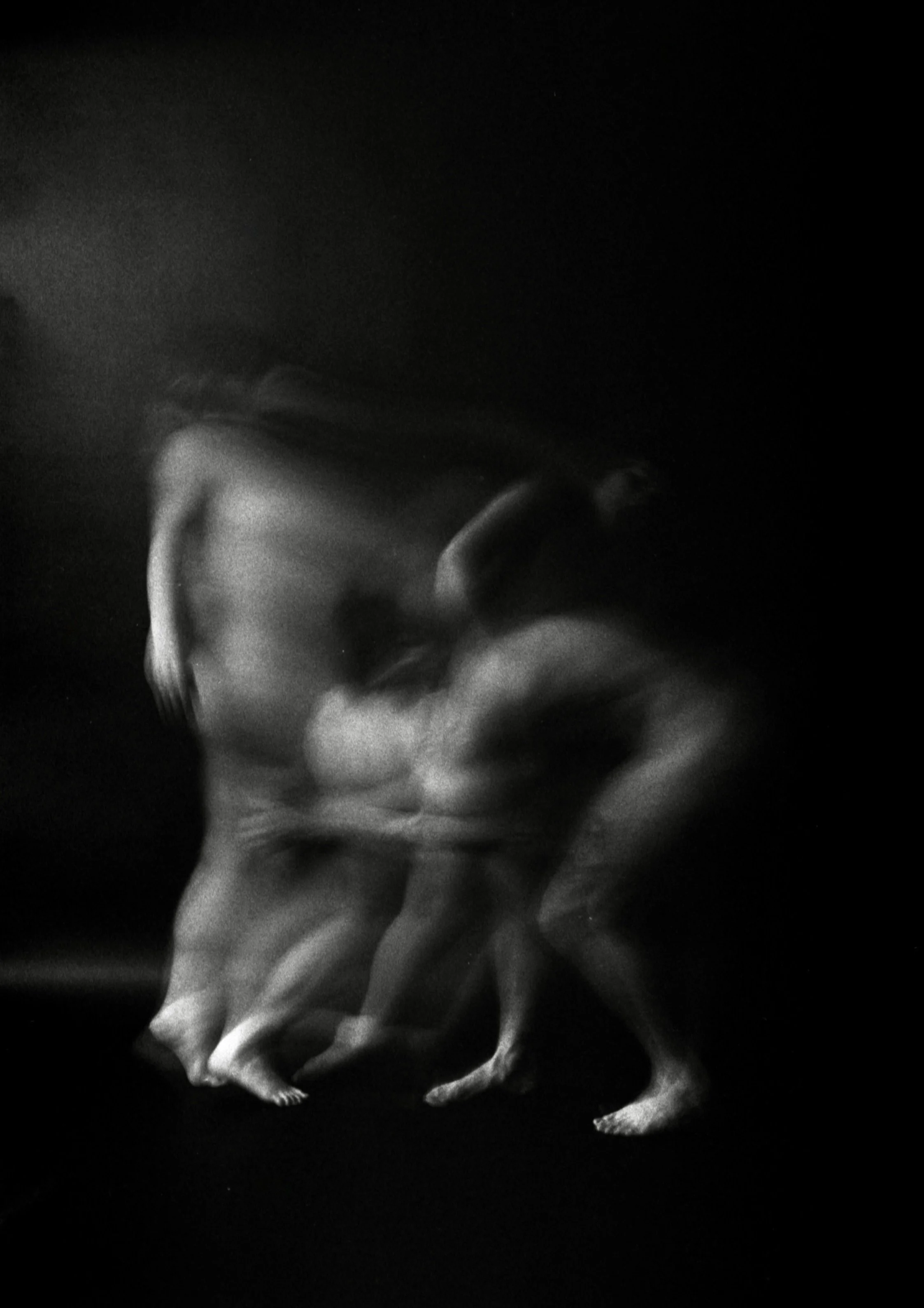 Black and white photo of smoke or vapor swirling against a dark background.
