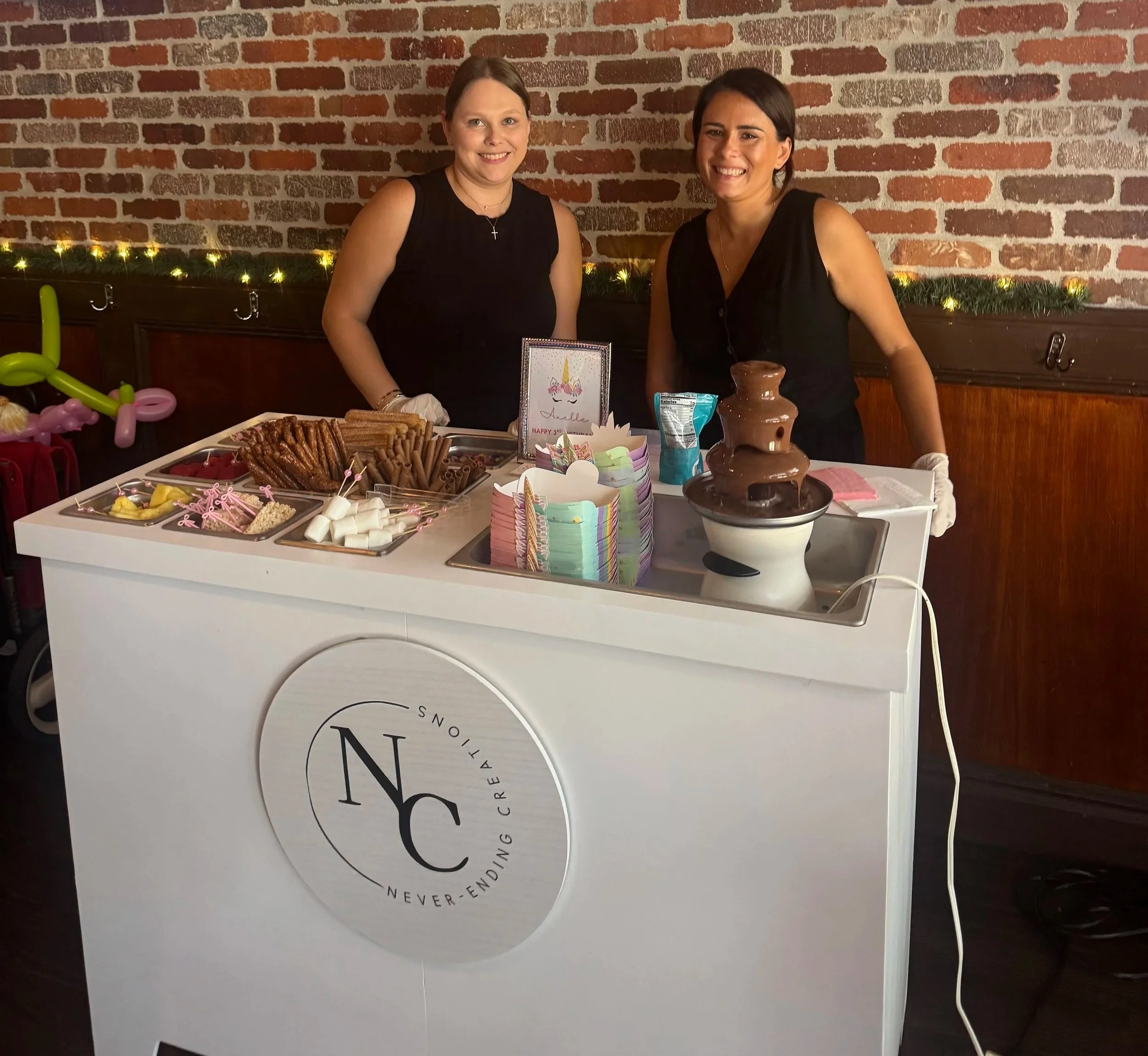 The founders of Never-Ending Creations working behind the chocolate fountain cart.