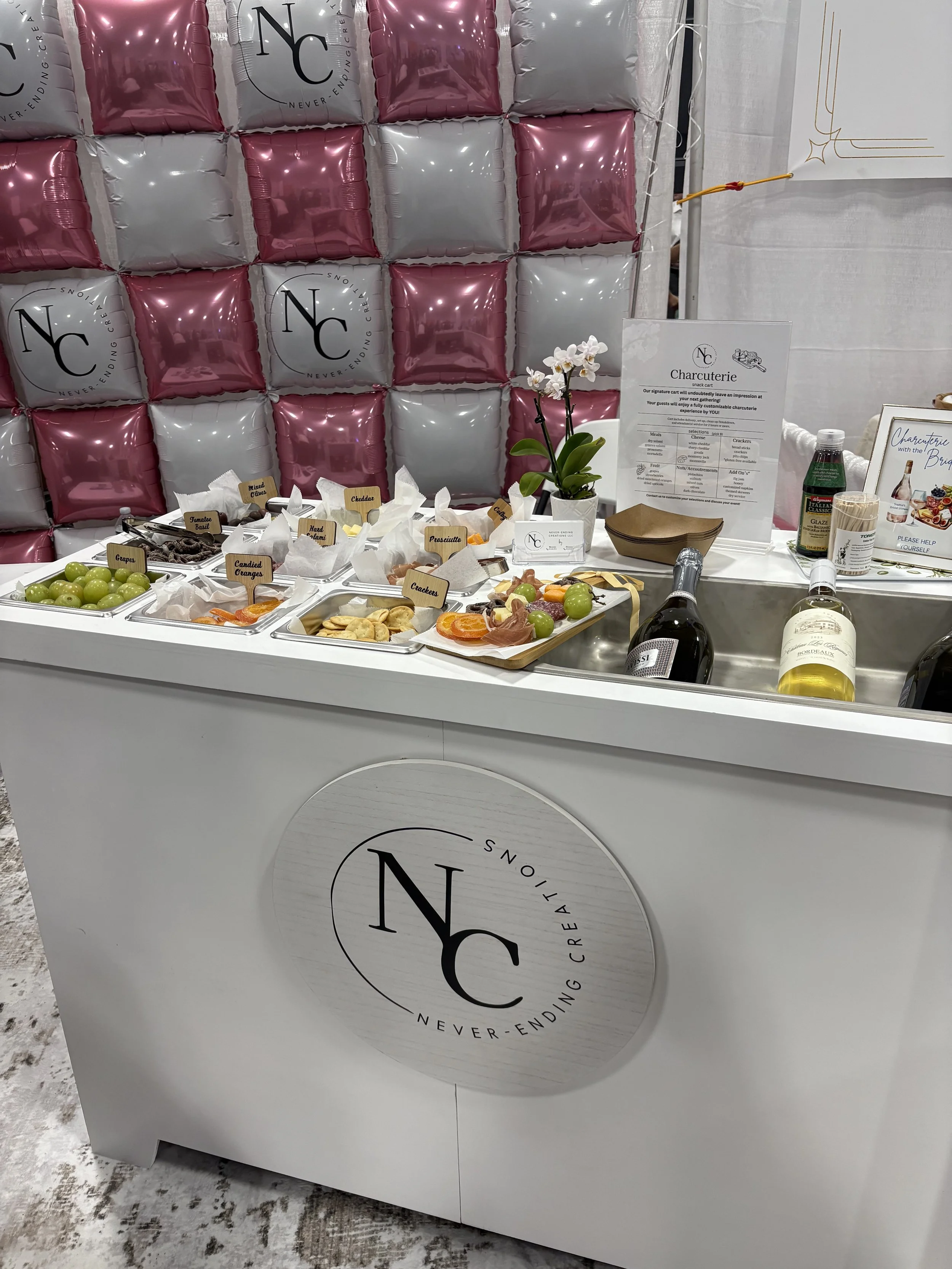 Charcuterie cart displayed in front of a balloon wall