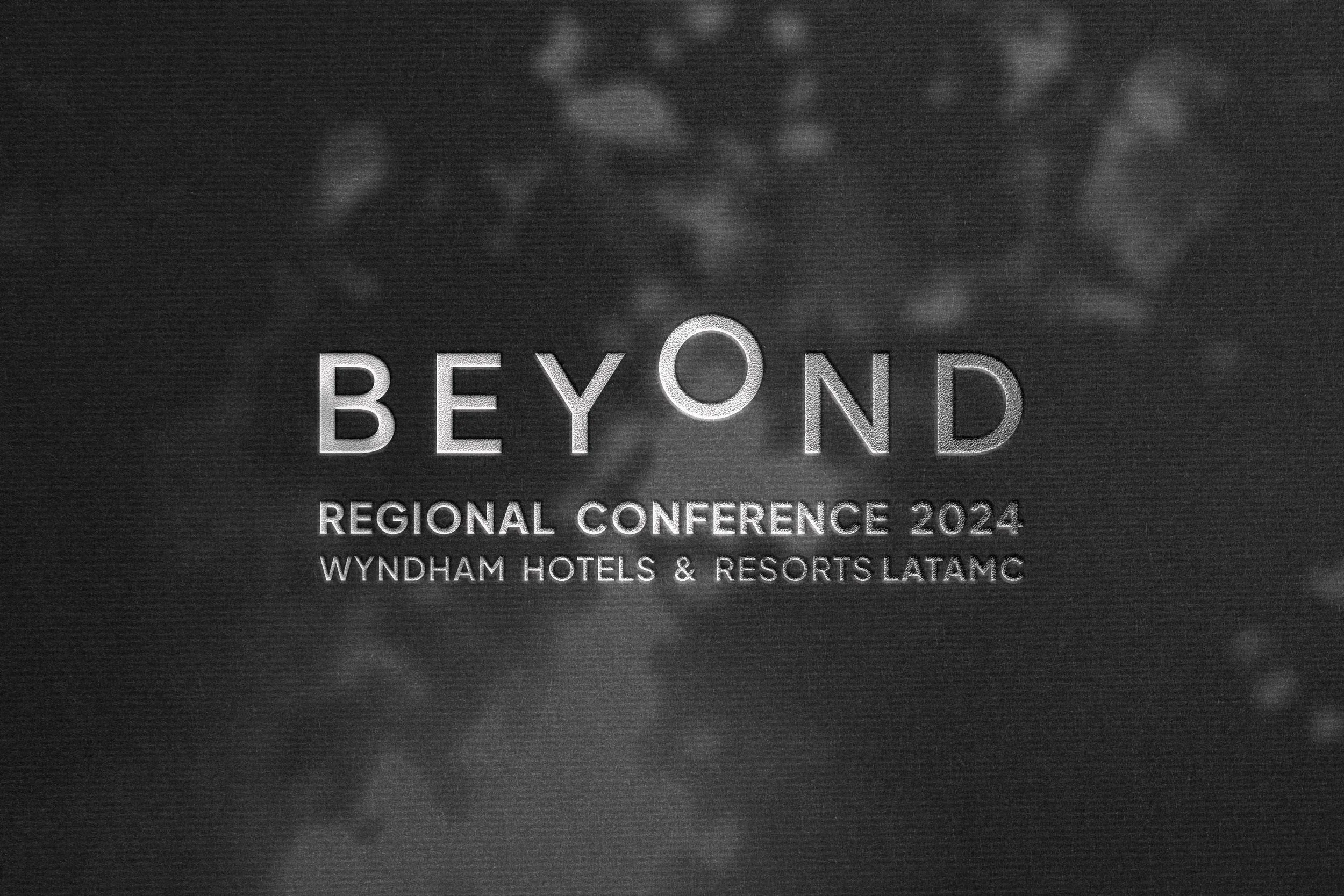Cartel en tonos grises que anuncia la Conferencia Regional 'Beyond' 2024 en los hoteles Wyndham y Resorts LATAM.