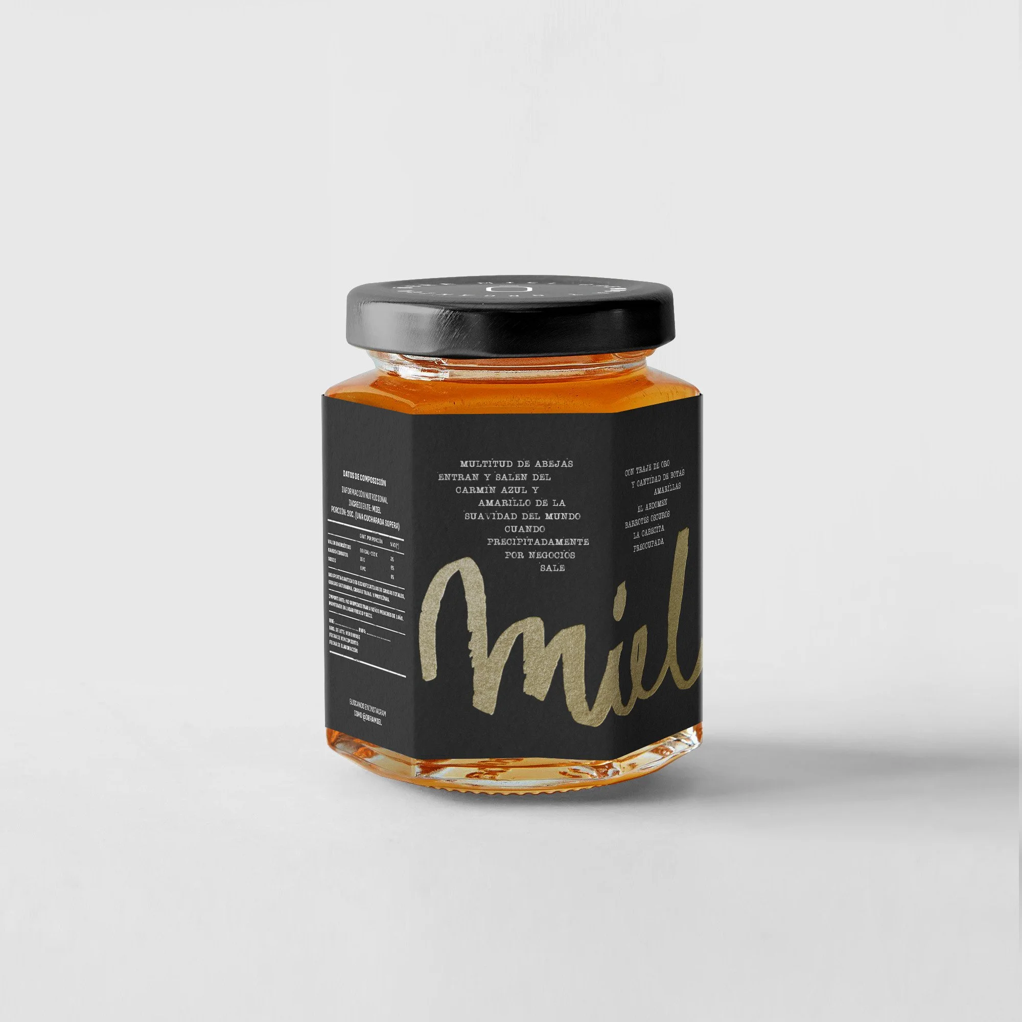 Frasco de miel con etiqueta negra y letras doradas que dice 'miel'