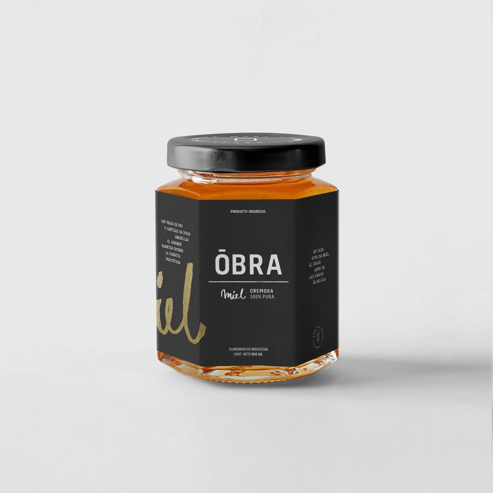 Frasco de miel con etiqueta negra que dice 'ÓBRA', miel cremosa y 100% pura, elaborado en Argentina.