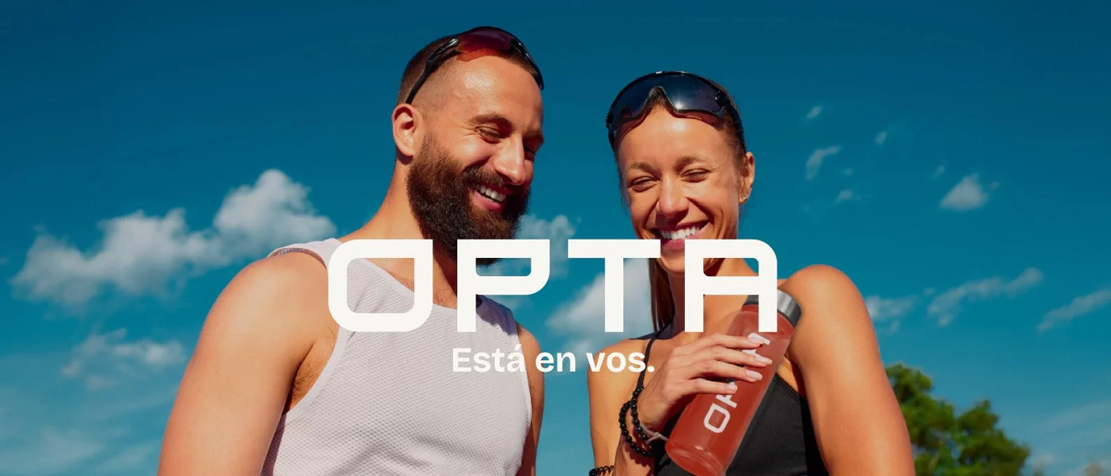 Una pareja sonriente con ropa deportiva disfrutando bajo un cielo azul, la mujer sostiene una botella con la marca OPTA.