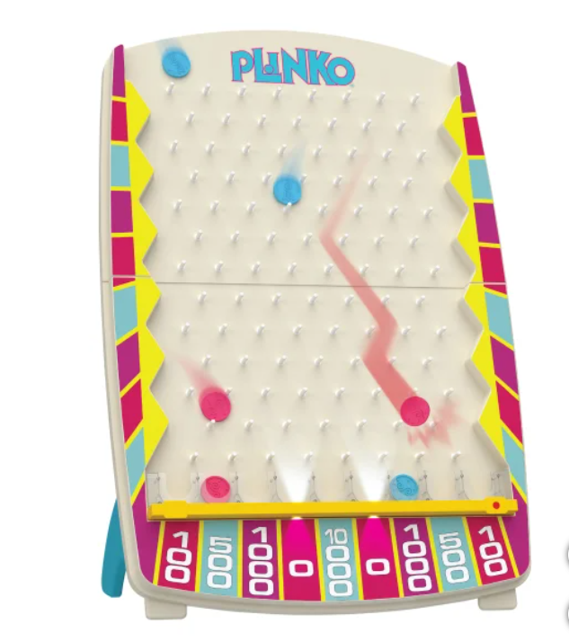 A vintage Plinko game with a white vertical board, colorful side accents, and a yellow ramp at the bottom. Several plastic discs are in motion on the board, with some near the bottom and some in the middle, showing a zigzag path. The game features a row of numbered slots at the bottom, including 100, 500, and 1000 points.