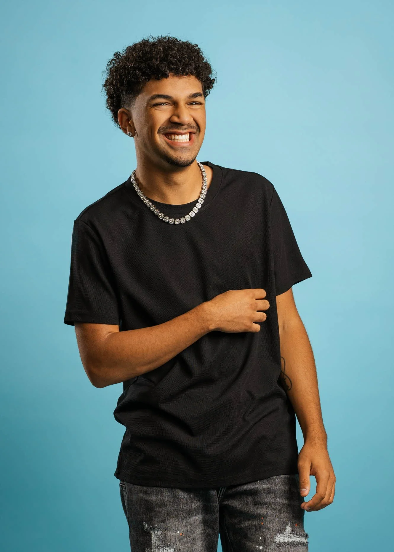 High school student in Phoenix laughing in front a light blue backdrop