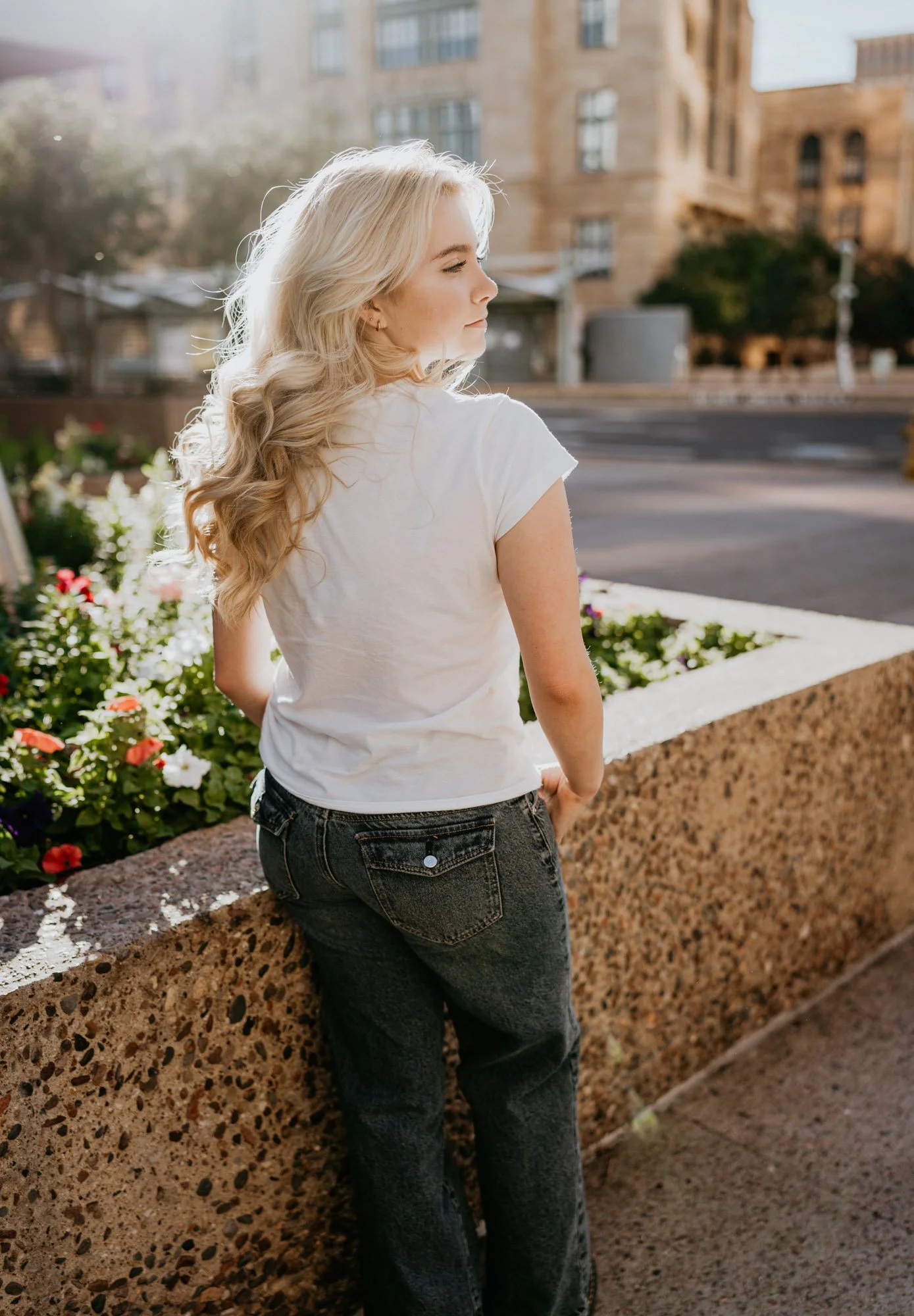 High School senior posing in front of a bed of flowers during a Phoenix Senior Session