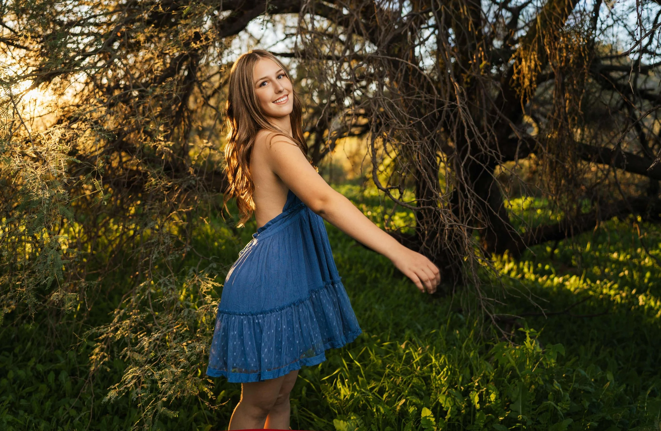 A senior girl from Phoenix dancing in a field of green grass