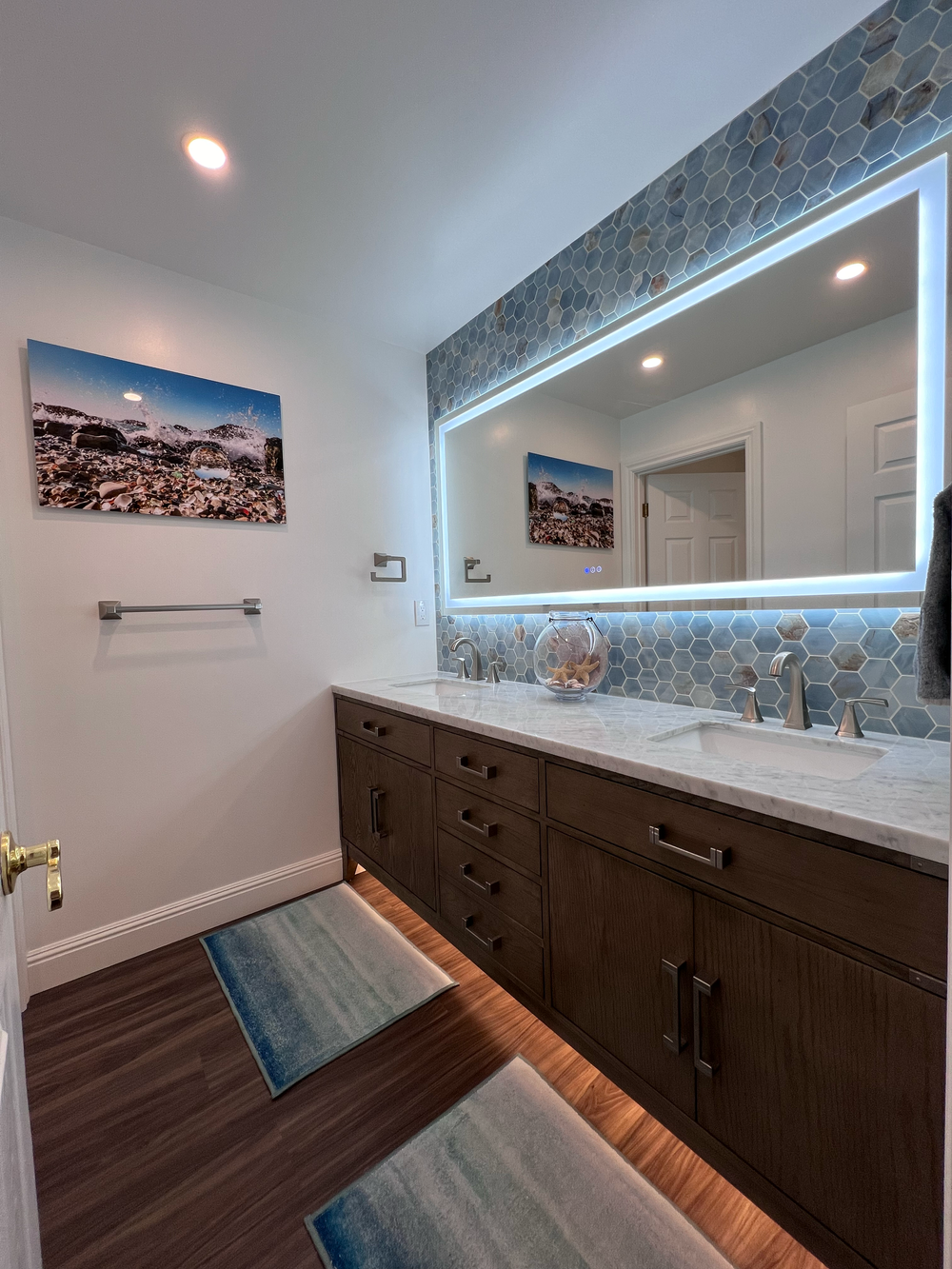 Bathroom vanity with a wooden cabinet, marble countertop, LED mirror and blue and beige hexagonal wall tile