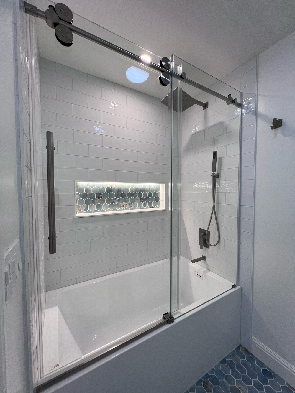 Bathroom with a glass shower enclosure, subway tile and hexagon tile floor