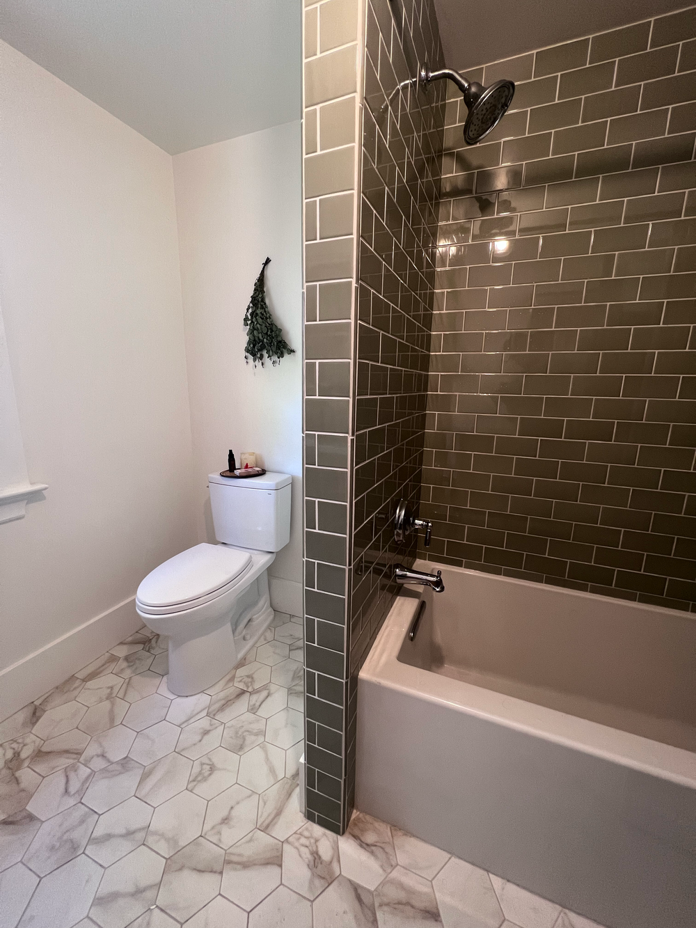 Bathroom remodel with a toilet, bathtub, shower and tiled walls