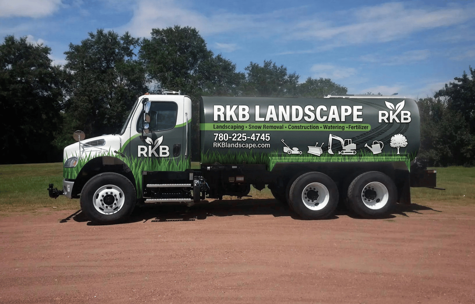 A landscaping truck with green and black branding for RKB LANDSCAPE, parked on a dirt area with grass and trees in the background. The truck has icons depicting lawn care and construction services, along with contact information.