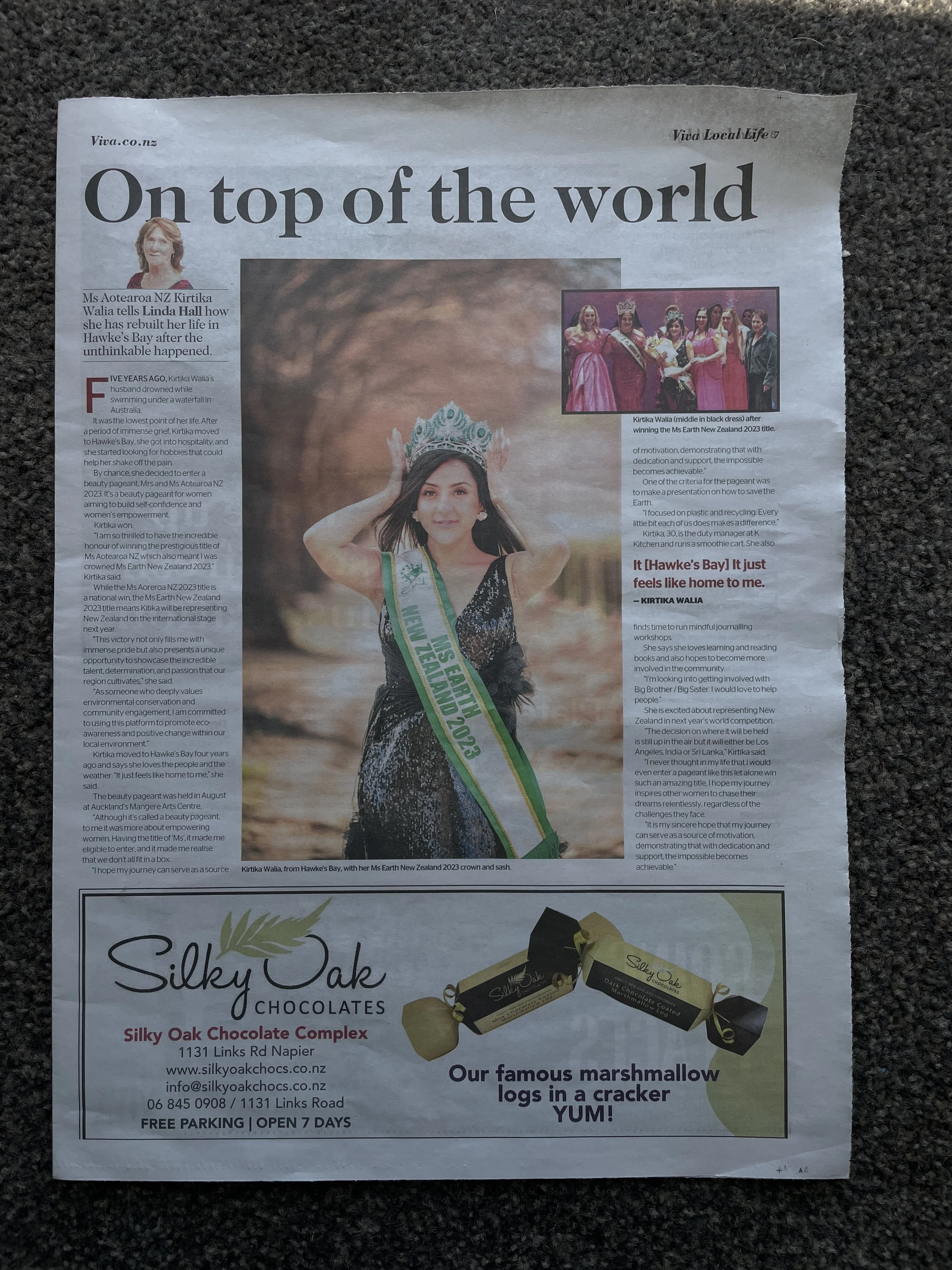 A newspaper article featuring Kirtika Walia, who won Miss Earth New Zealand 2023, wearing a crown and sash, standing outdoors near a body of water, with a secondary photo of her and other contestants in pink dresses.